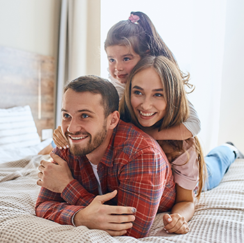 Smiling family on hotel room bed